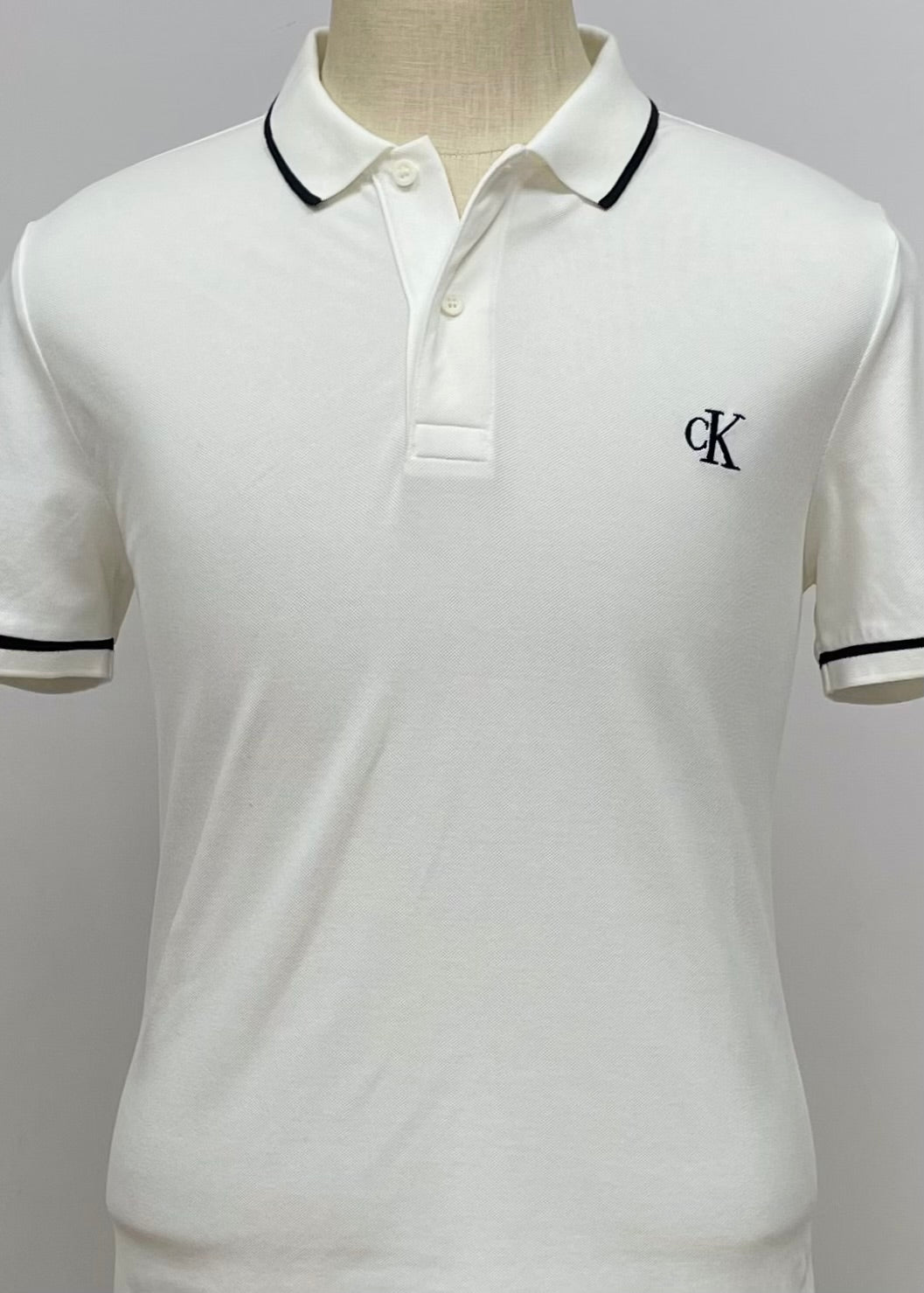 Camiseta Polo Calvin Klein CK color blanco con diseño de lineas en color negro Talla L Entalle Slim Fit