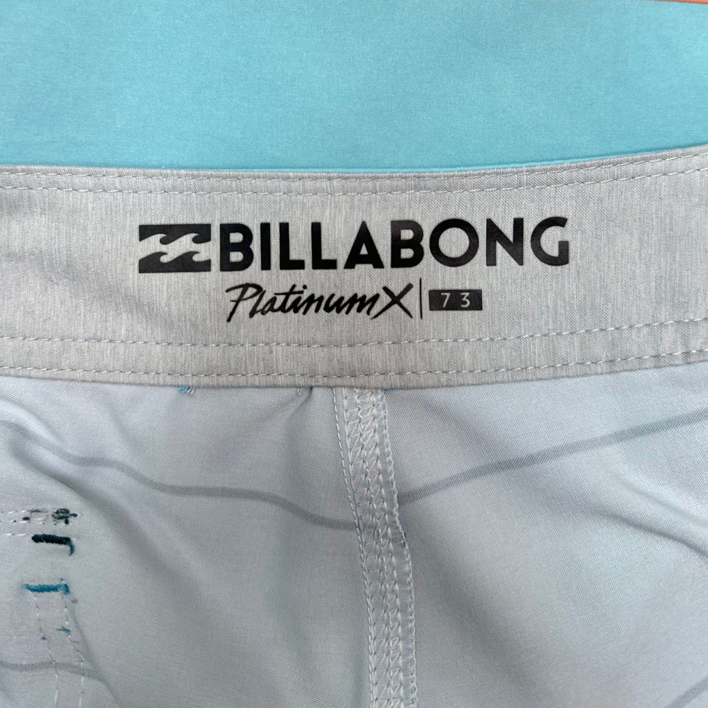 Short de baño Billabong 🏄🏽‍♂️ color celeste con patron de rayas en negro y naranja con logo en color blanco Talla S