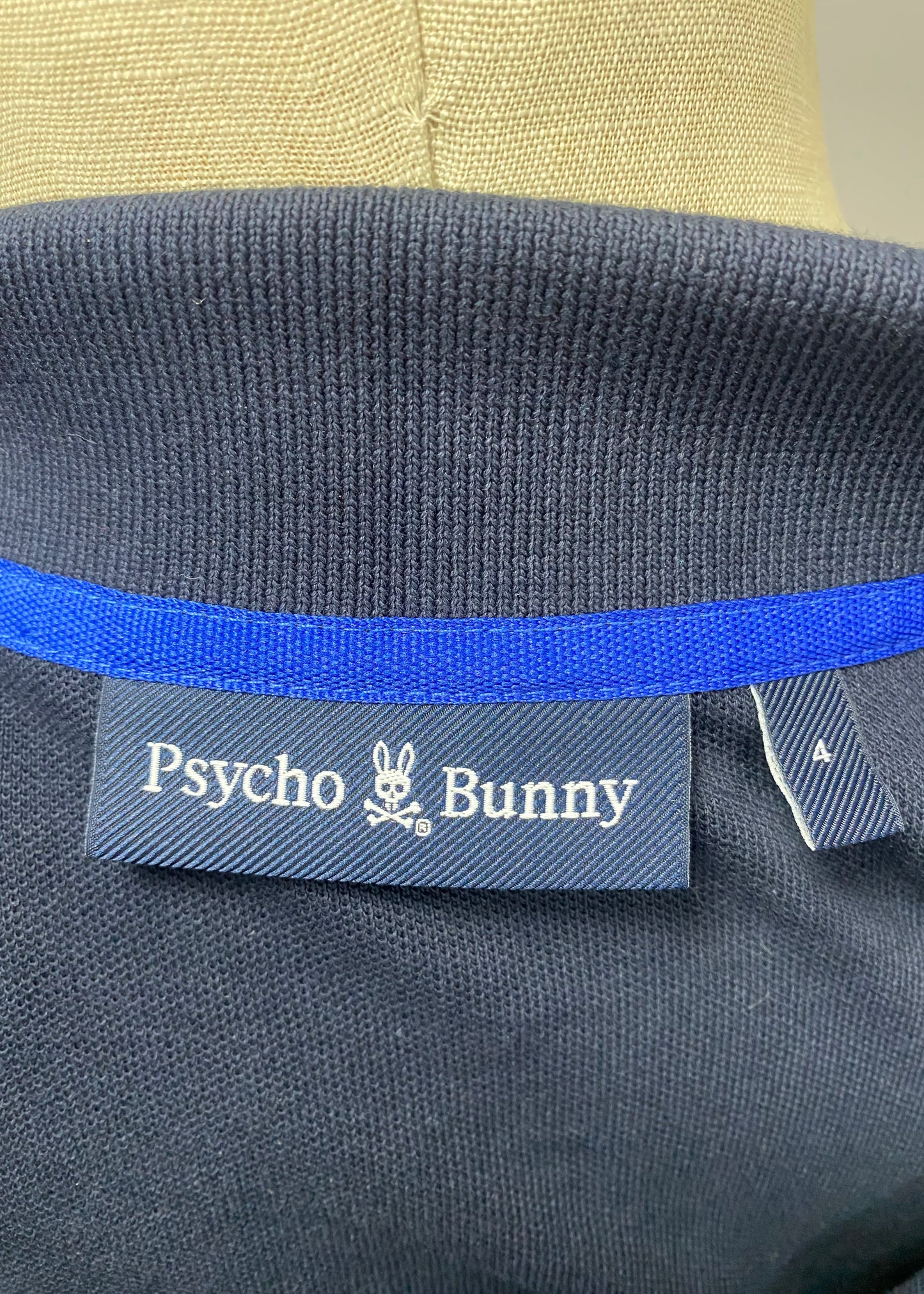 Camiseta Polo Psycho Bunny 🐰 Pique en color azul navy con diseño de cuello en verde intenso Talla S Entalle Regular