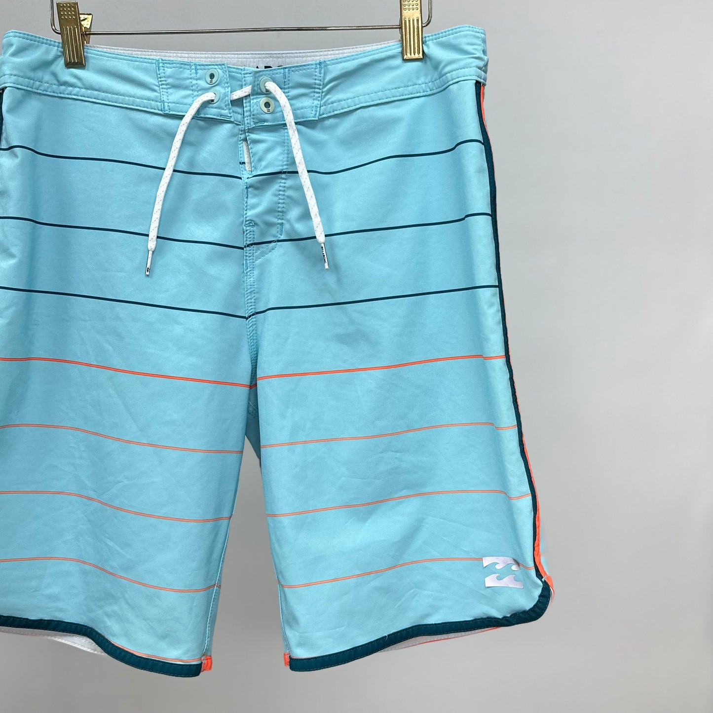 Short de baño Billabong 🏄🏽‍♂️ color celeste con patron de rayas en negro y naranja con logo en color blanco Talla S