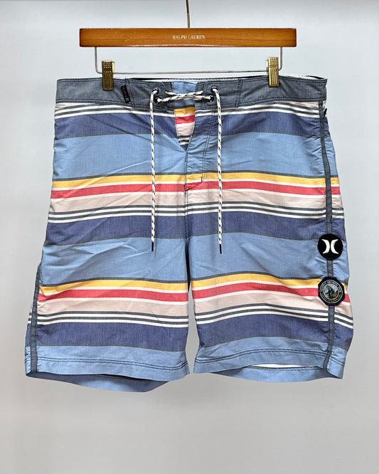 Short de baño Hurley 🏄🏽‍♂️ color celeste con franjas en amarillo, rojo y crema talla M