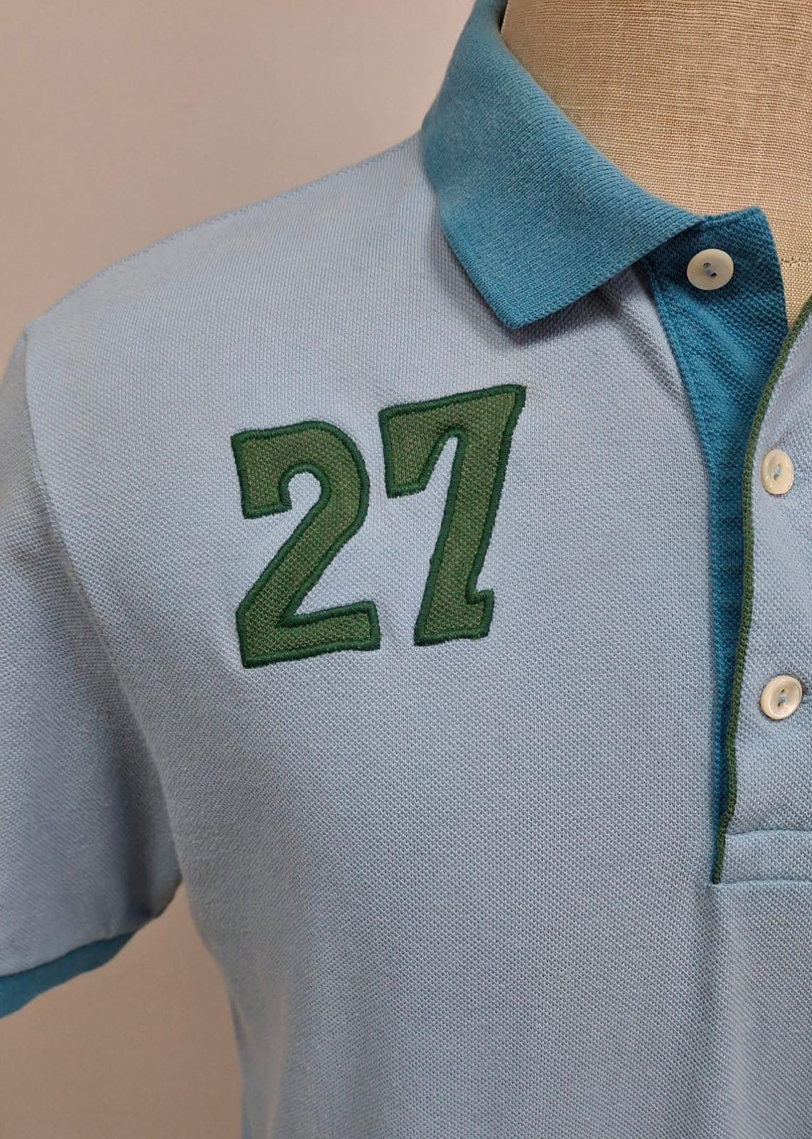 Camiseta Polo Lacoste 🐊 color celeste y diseño en cuello y manga color azul Talla L Entalle Regular