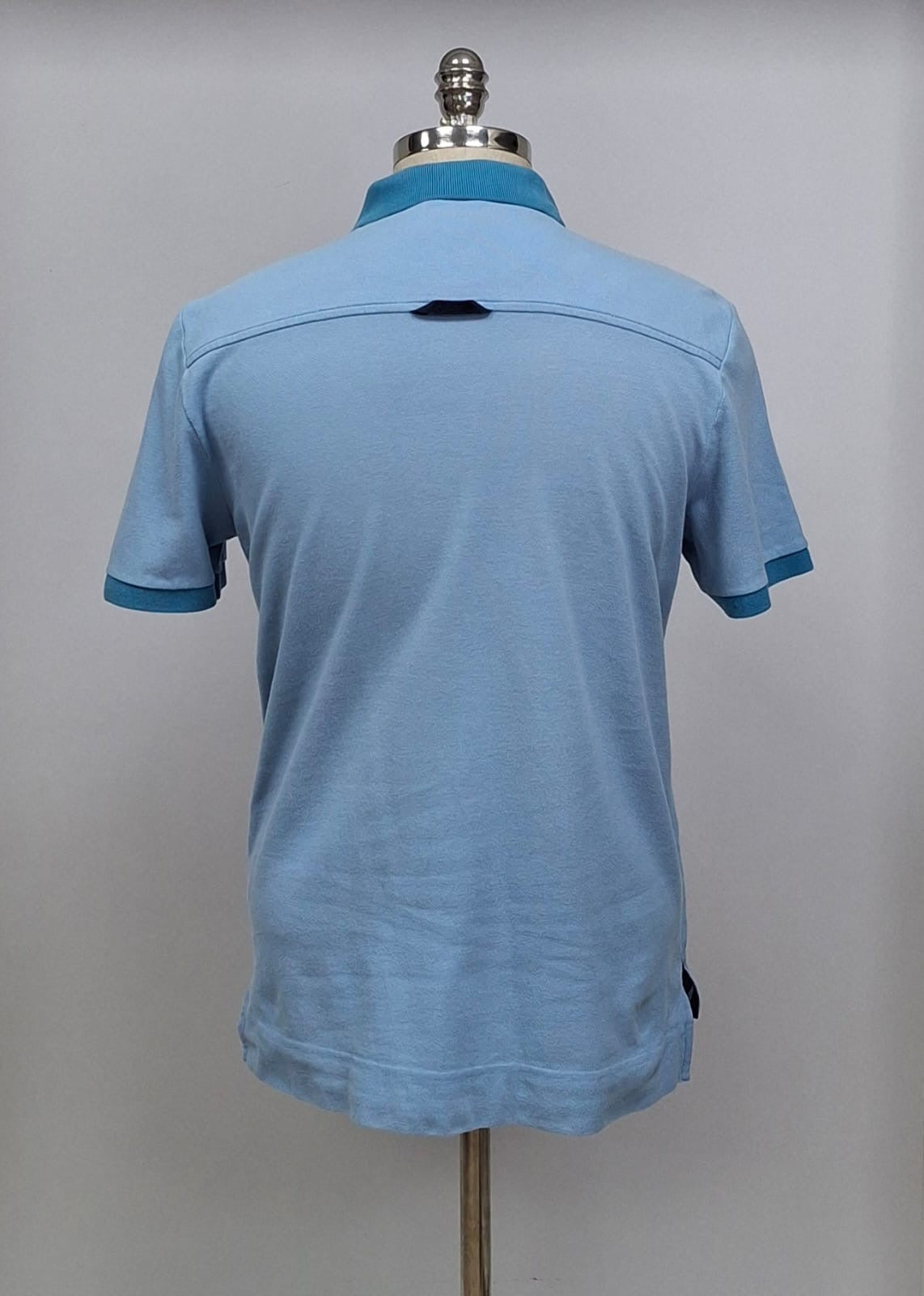 Camiseta Polo Lacoste 🐊 color celeste y diseño en cuello y manga color azul Talla L Entalle Regular