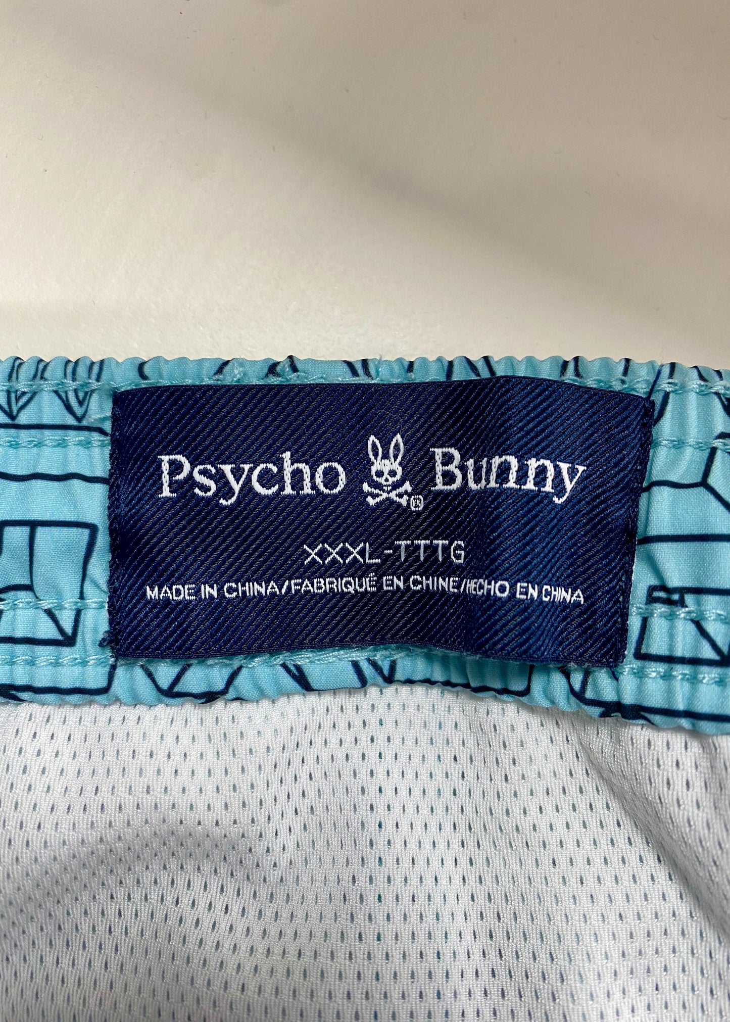 Short de baño Psycho Bunny 🐰  color celeste y logo en letras en negro Talla 3XL