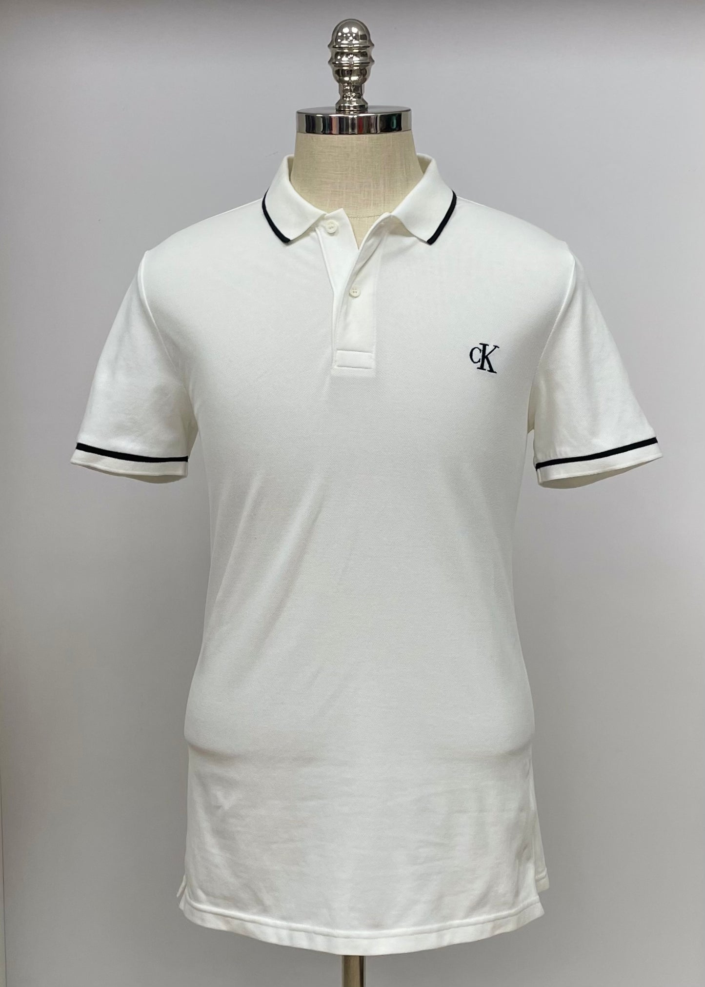 Camiseta Polo Calvin Klein CK color blanco con diseño de lineas en color negro Talla L Entalle Slim Fit