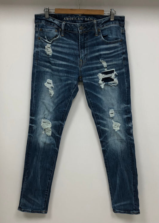 Pantalon jeans American Eagle 🦅  color azul y diseño descosido Talla 33x32 Corte Slim Fit