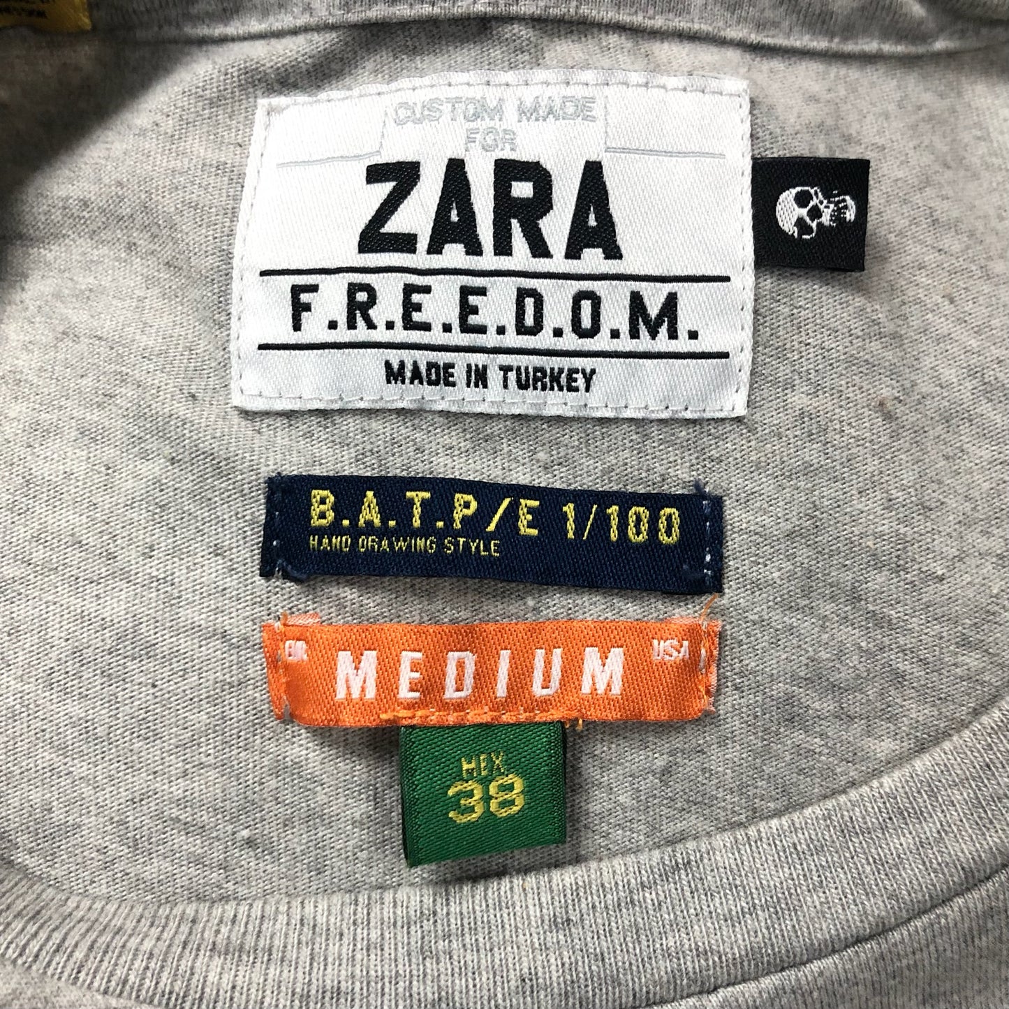 Camiseta cuello redondo Zara 🇪🇸 color gris con diseño de Graffitti en azul navy Talla S