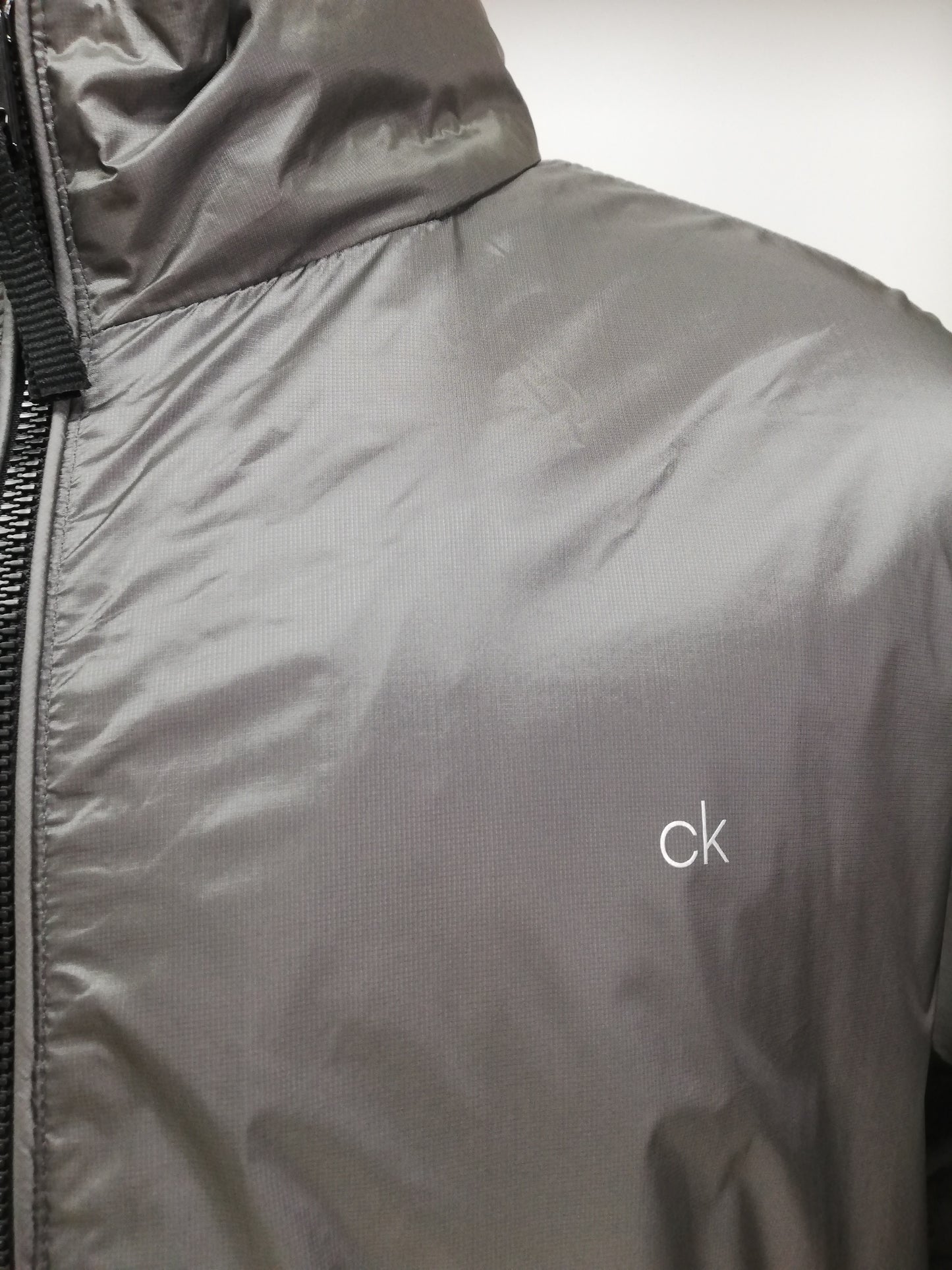 Jacket Calvin Klein color gris oscuro y negro con zíper completo con logo en color gris claro Talla XXL