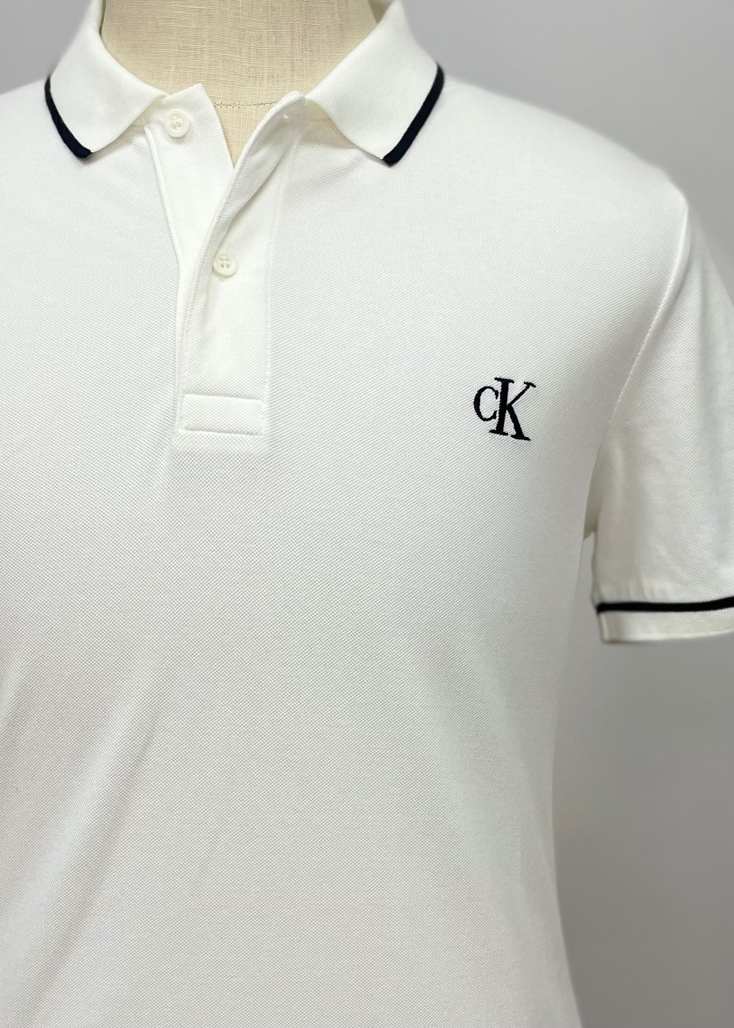 Camiseta Polo Calvin Klein CK color blanco con diseño de lineas en color negro Talla L Entalle Slim Fit