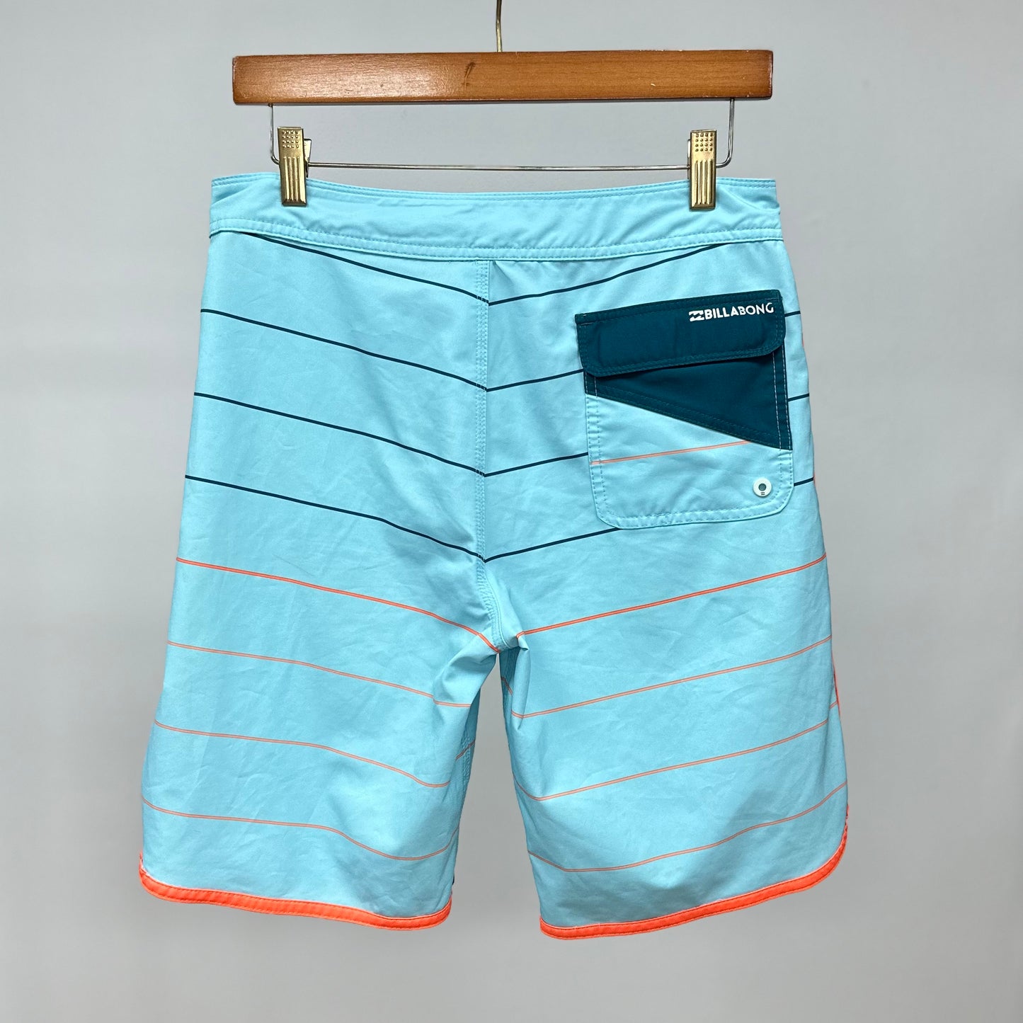 Short de baño Billabong 🏄🏽‍♂️ color celeste con patron de rayas en negro y naranja con logo en color blanco Talla S