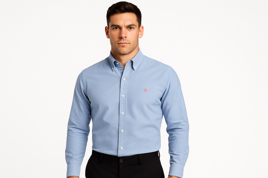 Athletic model wearing light blue shirt with button-down collar and crest logo