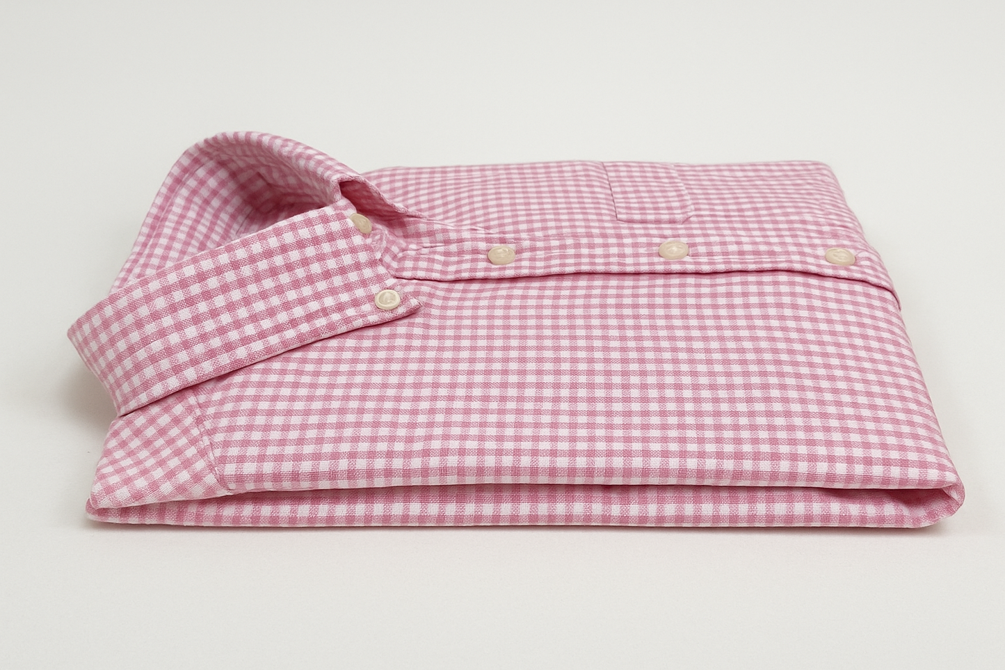 Camisa de cuadros rosa y blanca doblada vista lateral
