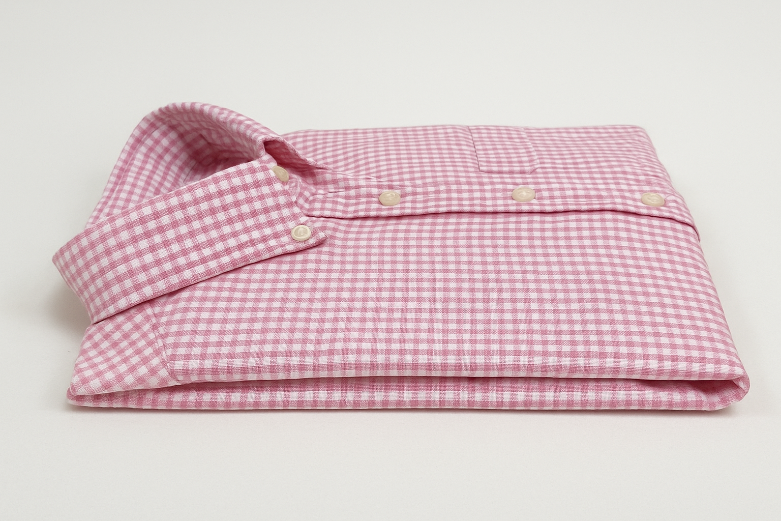 Camisa de cuadros rosa y blanca doblada vista lateral