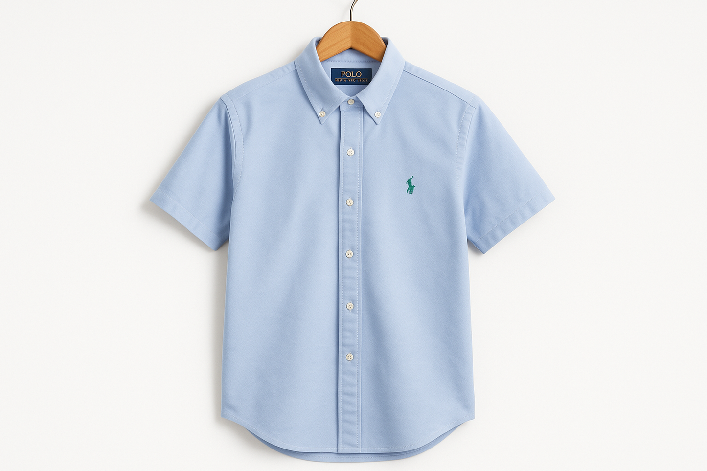 Camisa Polo Ralph Lauren celeste con logo verde colgada en percha