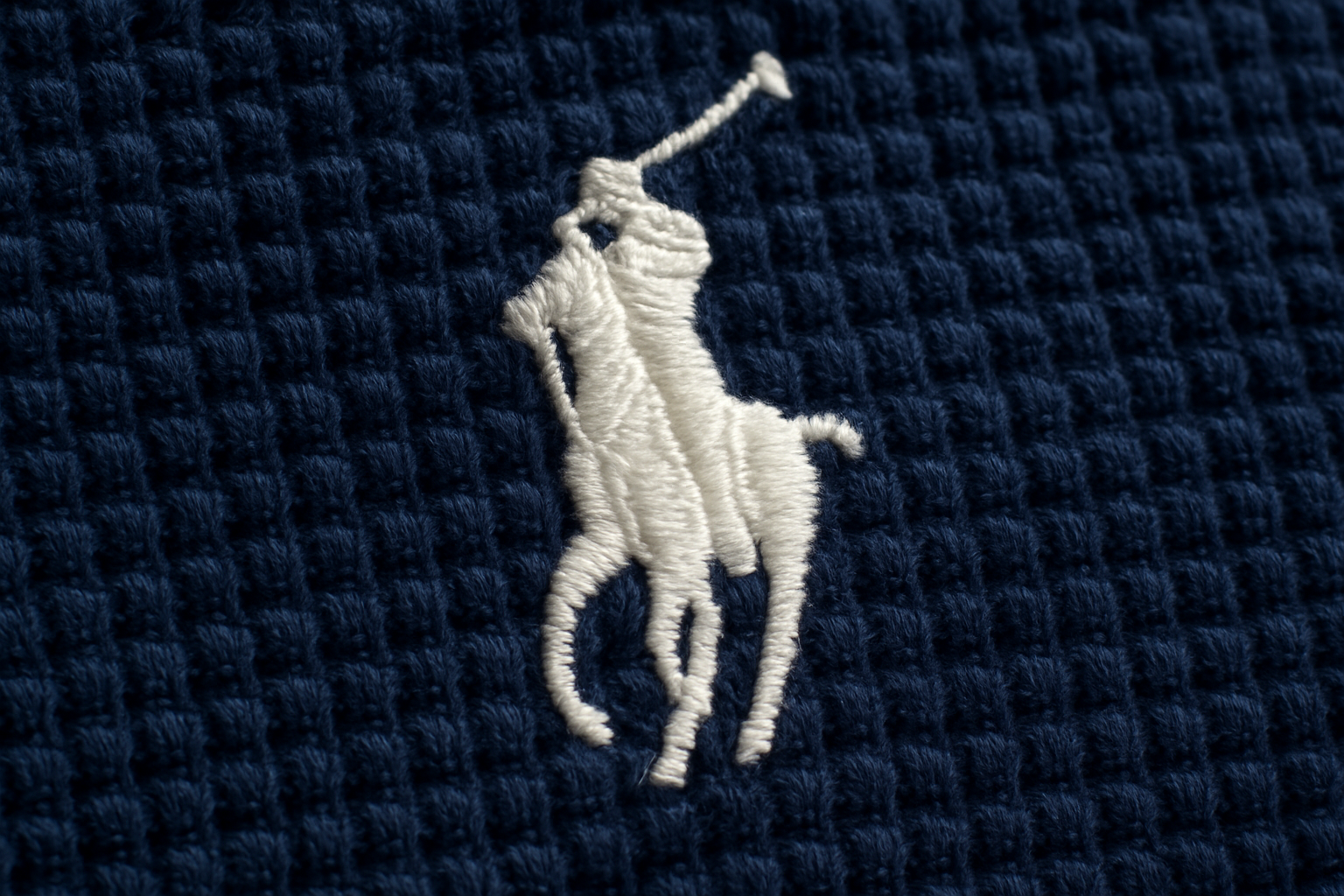 Detalle logo blanco sobre waffle navy