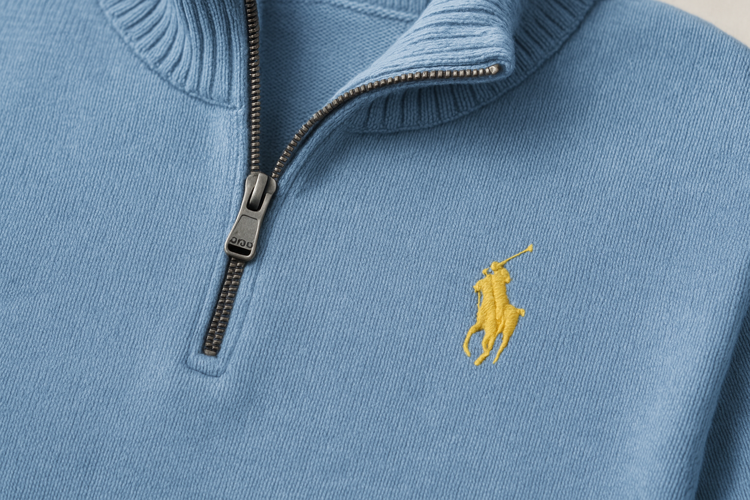 Detalle quarter-zip y logo amarillo