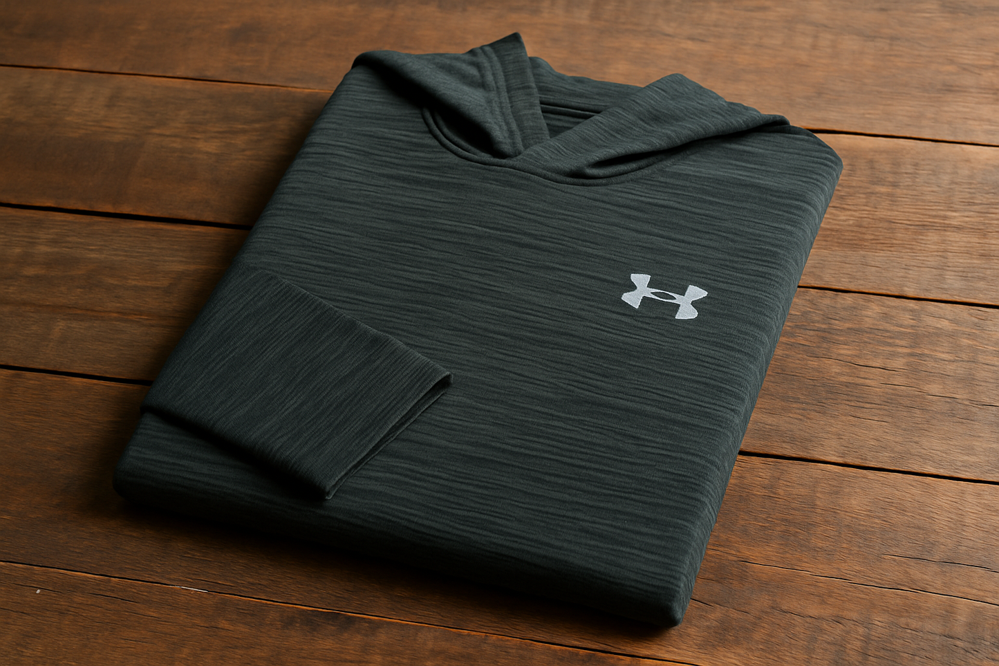 Hoodie Under Armour verde texturizada - Doblada en superficie de madera