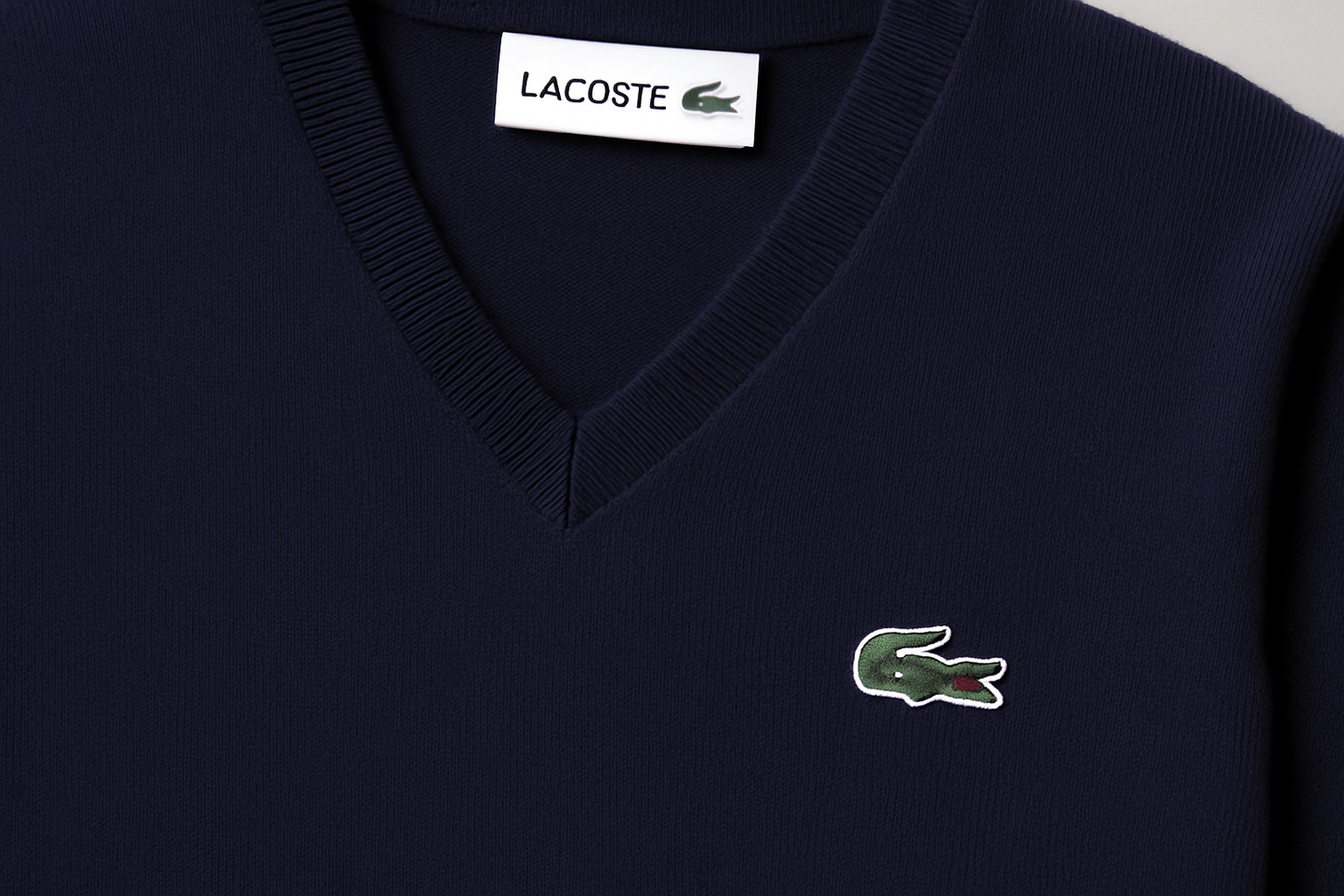 Primer plano del suéter Lacoste azul navy con logo del cocodrilo verde