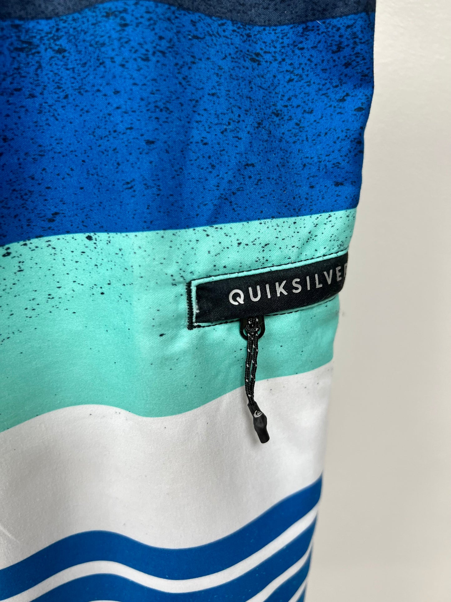 Traje de baño QuickSilver 🏄🏽‍♂️ con patrón de rayas en color azul, celeste y blanco con logo en color negro Talla Medium (32)