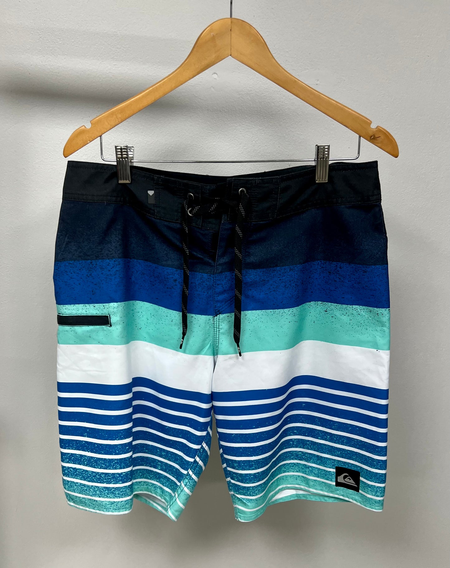 Traje de baño QuickSilver 🏄🏽‍♂️ con patrón de rayas en color azul, celeste y blanco con logo en color negro Talla Medium (32)