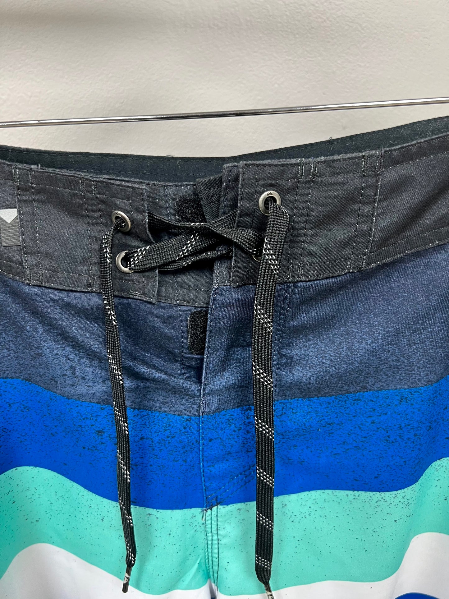 Traje de baño QuickSilver 🏄🏽‍♂️ con patrón de rayas en color azul, celeste y blanco con logo en color negro Talla Medium (32)