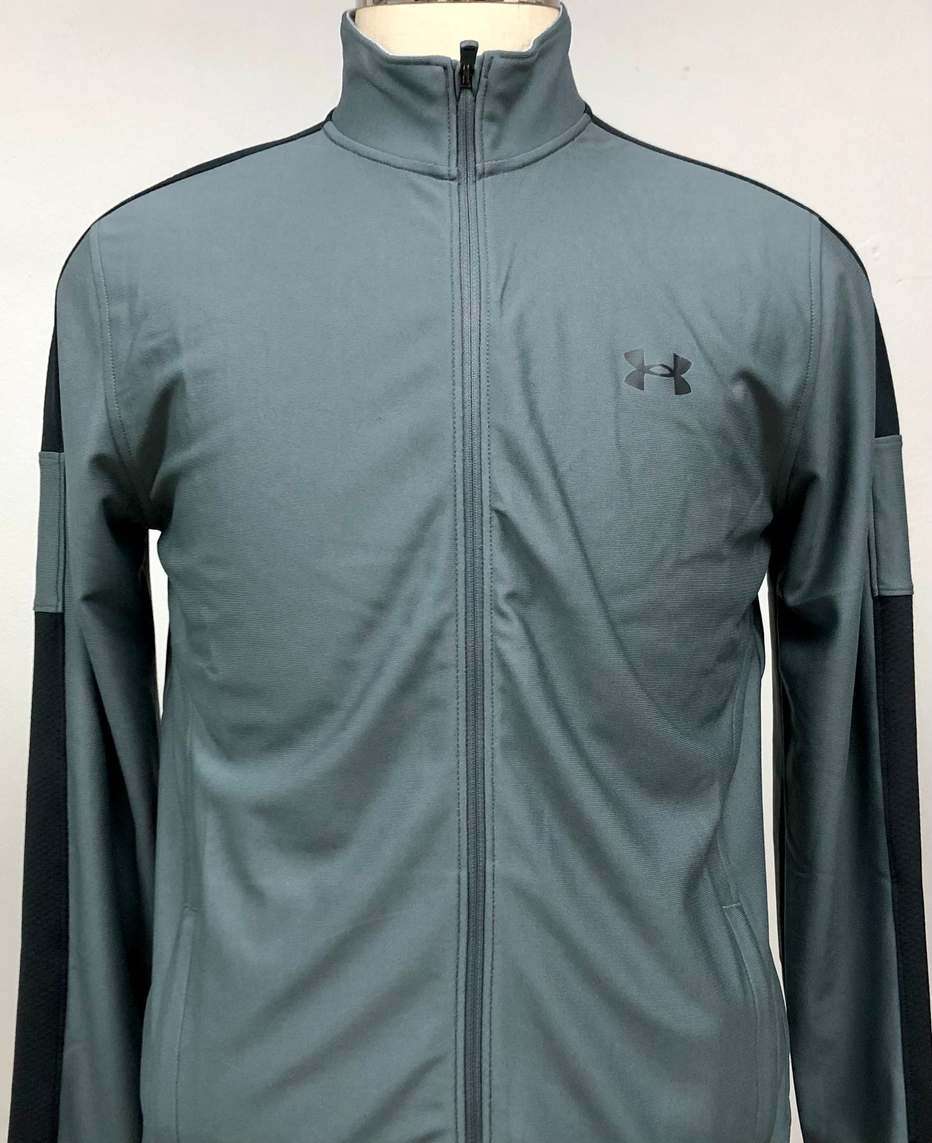 Sueter Jersey Under Armour color gris oscuro y logo en color negro Talla M
