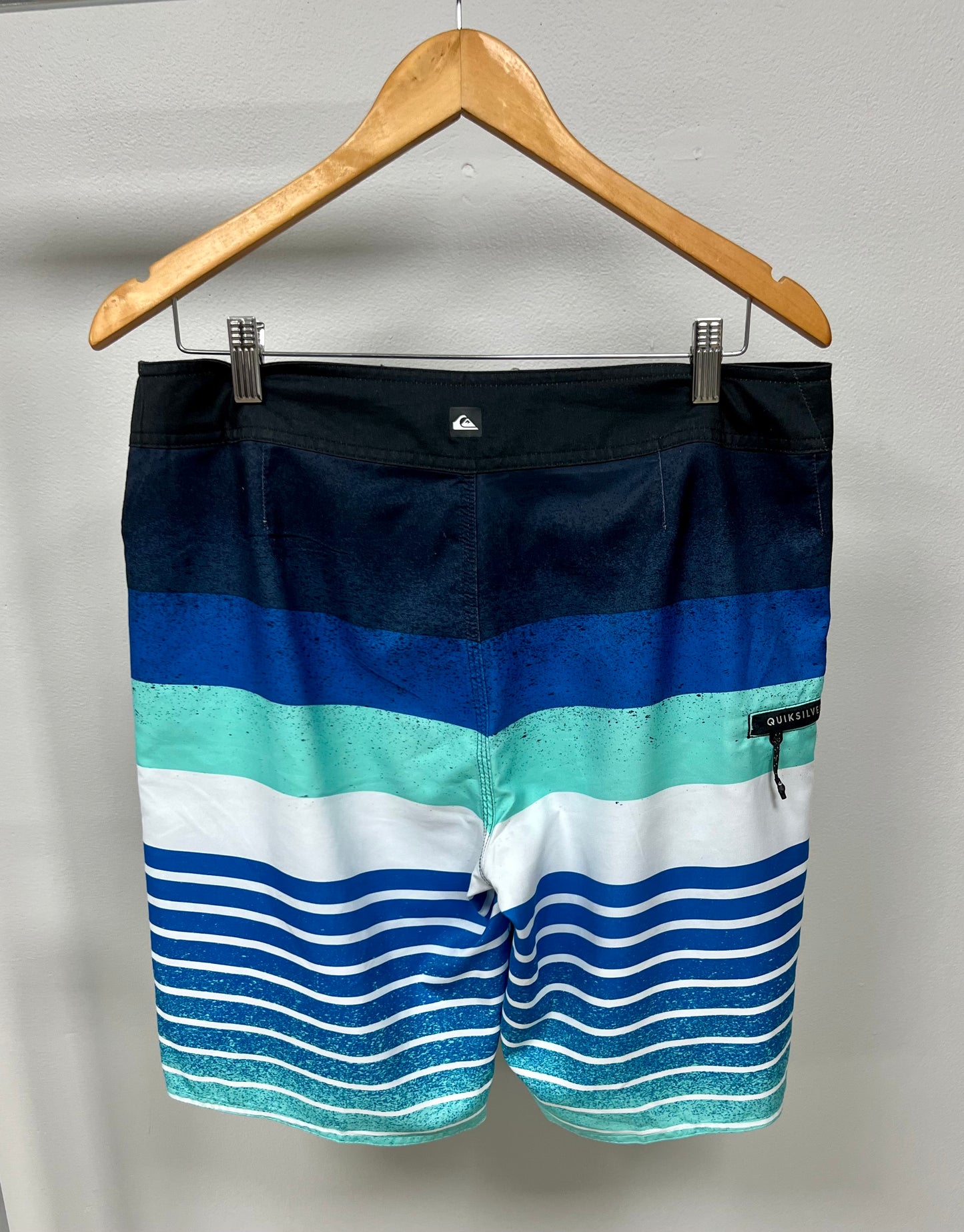 Traje de baño QuickSilver 🏄🏽‍♂️ con patrón de rayas en color azul, celeste y blanco con logo en color negro Talla Medium (32)