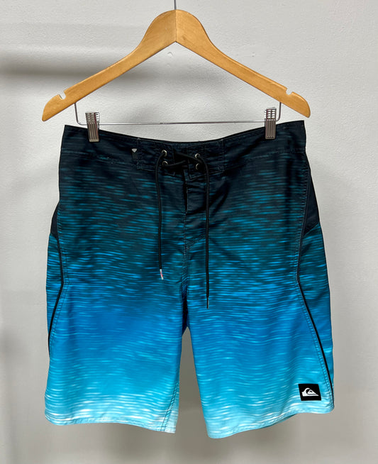 Traje de baño QuickSilver 🏄🏽‍♂️ con diseño degradado en color negro, azul y blanco con logo en color negro Talla Medium (32)